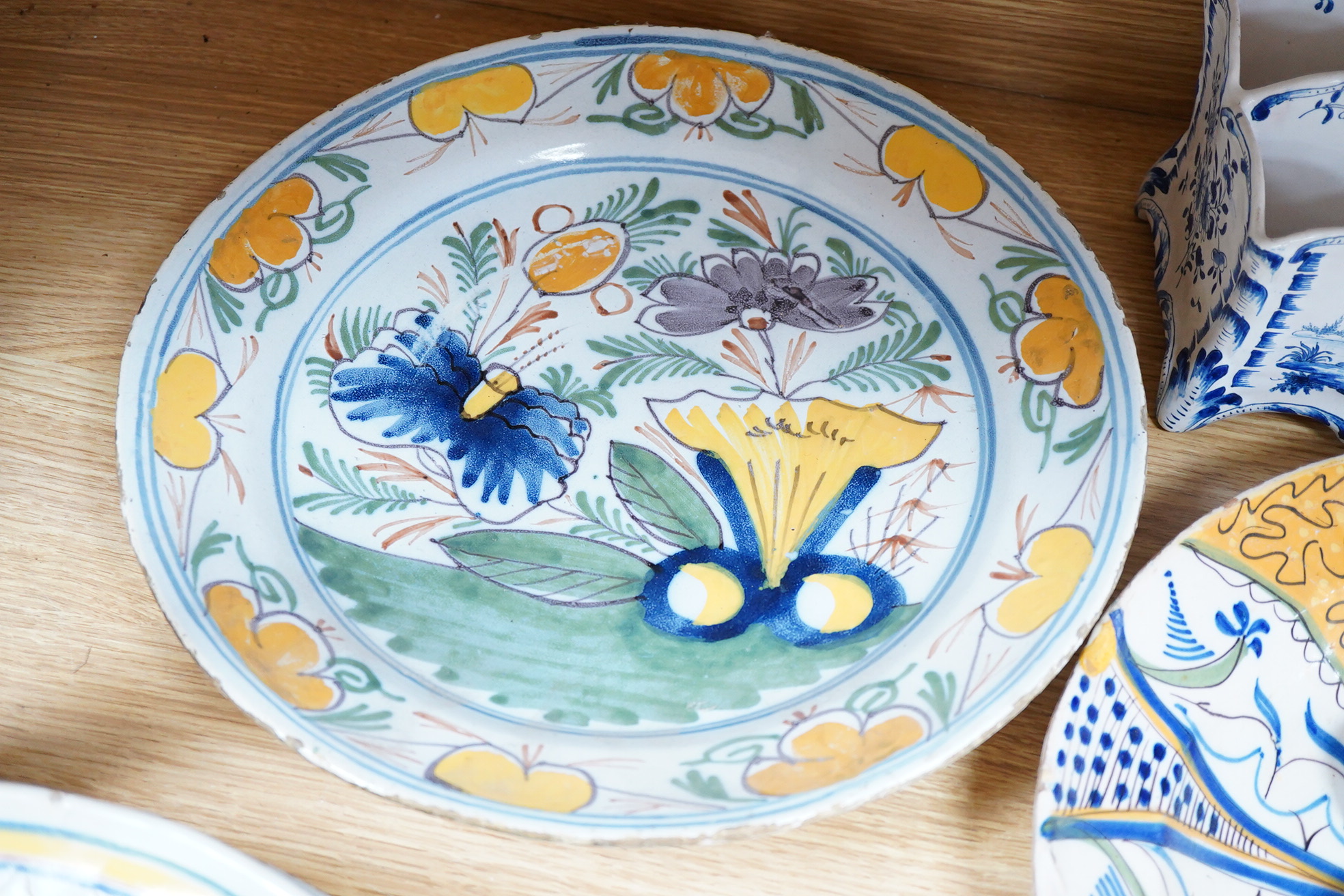 Two 18th century Delft polychrome chargers, five other faience chargers, a rectangular 19th century French faience dish and a blue and white letter rack